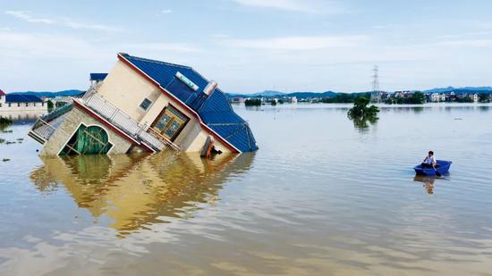 7月12日上午，江西上饶市鄱阳县油墩街镇，多个村庄浸泡在洪水中，部分房屋被冲垮。图/人民视觉